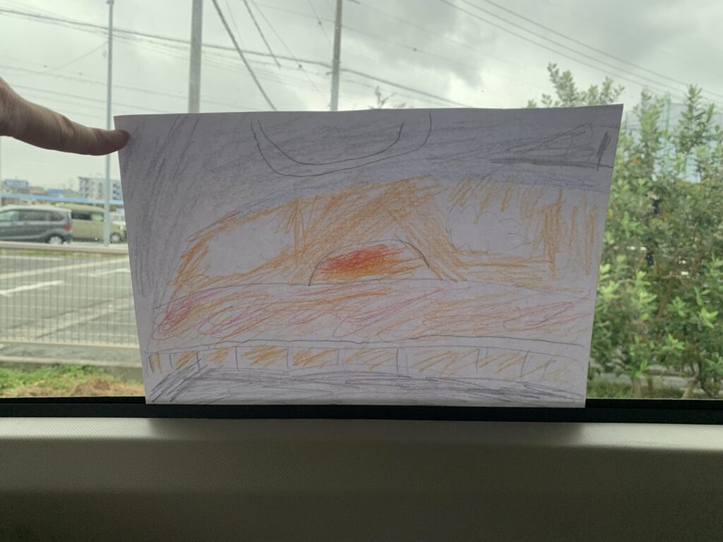 車からみた夕日の海